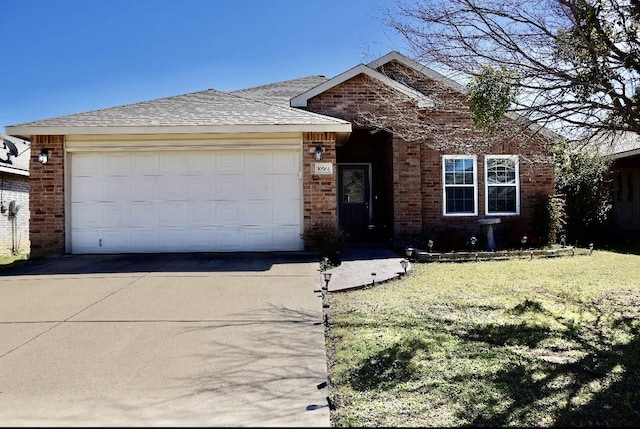 view of front of property featuring brick siding, a shingled roof, concrete driveway, an attached garage, and a front yard