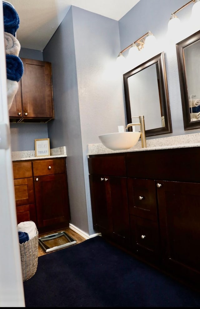 bathroom with vanity, baseboards, and wood finished floors