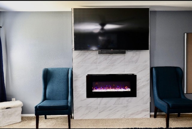 living area with carpet and a fireplace