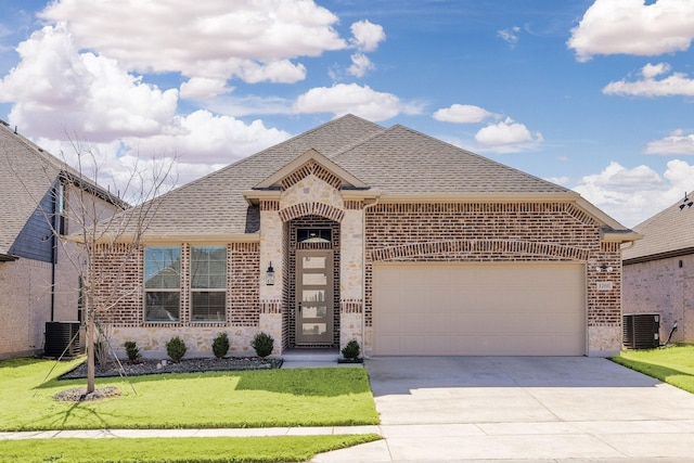 view of front facade with brick siding, roof with shingles, concrete driveway, an attached garage, and a front yard