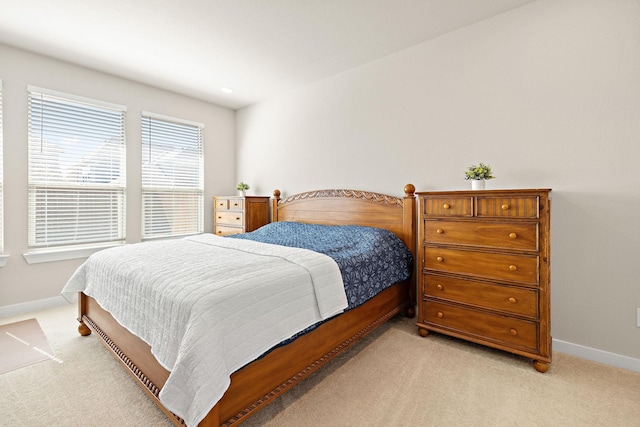 bedroom with light carpet and baseboards