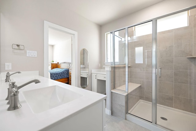 ensuite bathroom featuring a stall shower, tile patterned flooring, vanity, and ensuite bathroom