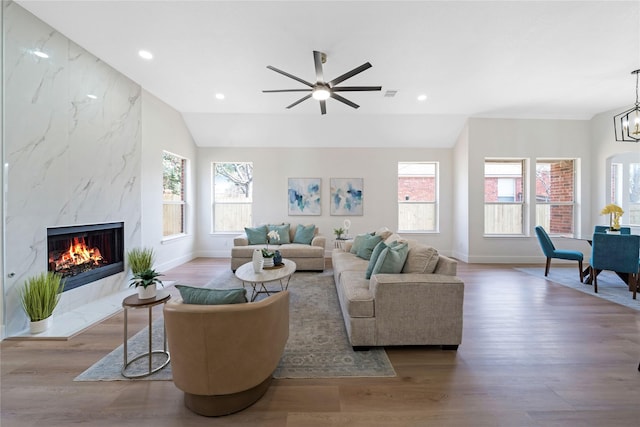 living area with a wealth of natural light, a fireplace, recessed lighting, and wood finished floors