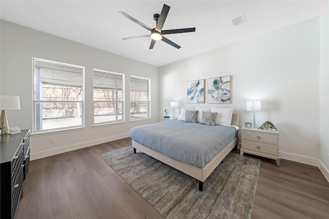 bedroom featuring ceiling fan, dark wood-type flooring, visible vents, and baseboards