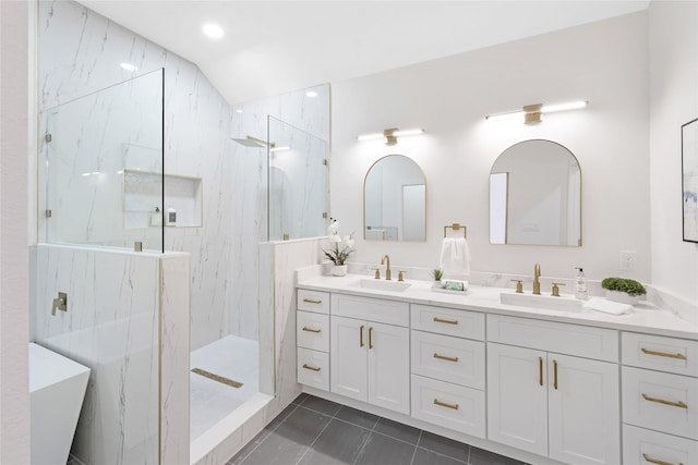 bathroom with tile patterned flooring, a sink, a marble finish shower, and double vanity