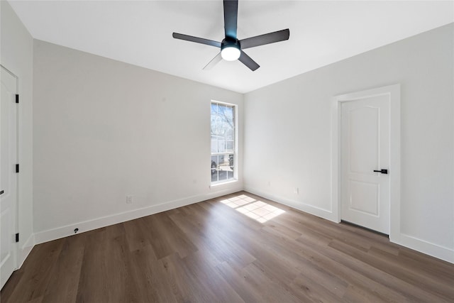 empty room with a ceiling fan, baseboards, and wood finished floors