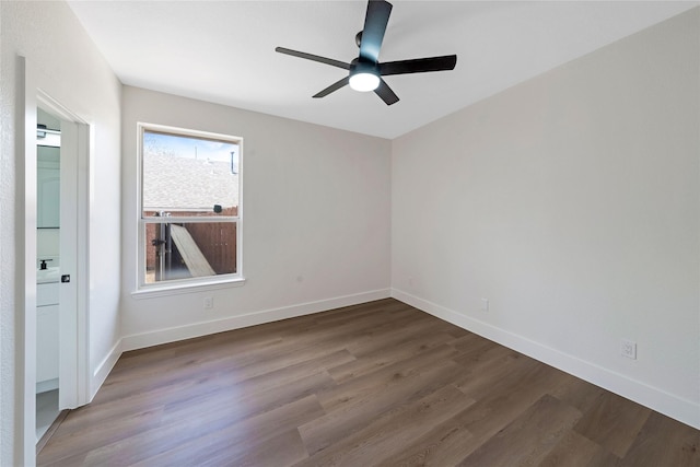 empty room featuring a ceiling fan, baseboards, and wood finished floors