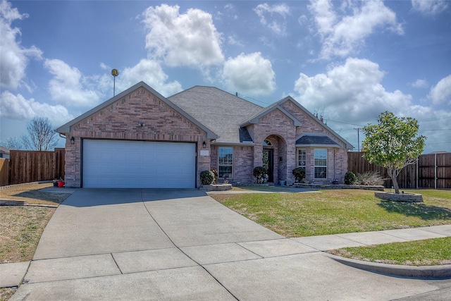 view of front of house featuring concrete driveway, roof with shingles, fence, a front lawn, and brick siding