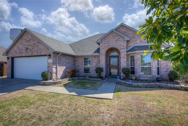 view of front of property with a garage, brick siding, concrete driveway, roof with shingles, and a front yard