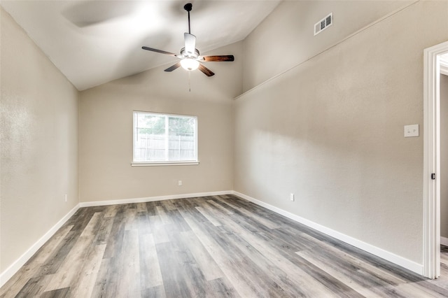 unfurnished room with baseboards, visible vents, vaulted ceiling, and wood finished floors