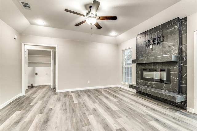 unfurnished living room featuring vaulted ceiling, a fireplace, baseboards, and wood finished floors