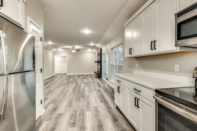 kitchen featuring white cabinets, ceiling fan, stainless steel appliances, light countertops, and light wood-style floors