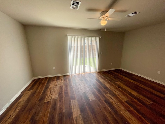 spare room featuring dark wood-style floors, baseboards, and visible vents