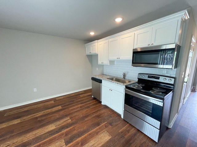 kitchen featuring dark wood-style floors, tasteful backsplash, appliances with stainless steel finishes, white cabinets, and a sink