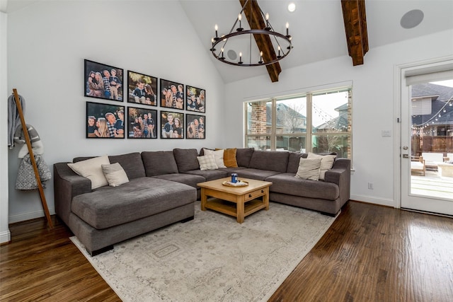 living area with an inviting chandelier, baseboards, high vaulted ceiling, and wood finished floors