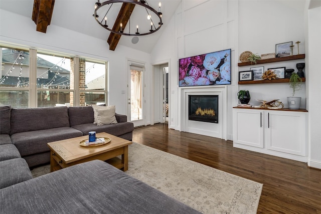 living room with a chandelier, high vaulted ceiling, dark wood-style flooring, beam ceiling, and a glass covered fireplace