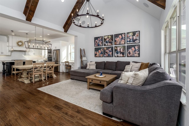 living room with an inviting chandelier, high vaulted ceiling, dark wood-style flooring, and beam ceiling