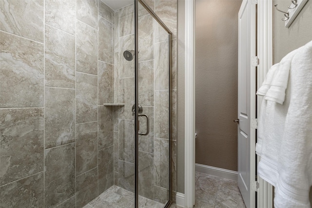 full bath with a shower stall and baseboards