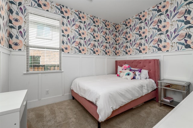 bedroom with a wainscoted wall, a decorative wall, and wallpapered walls