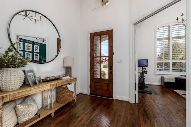 entrance foyer with baseboards, a chandelier, and wood finished floors