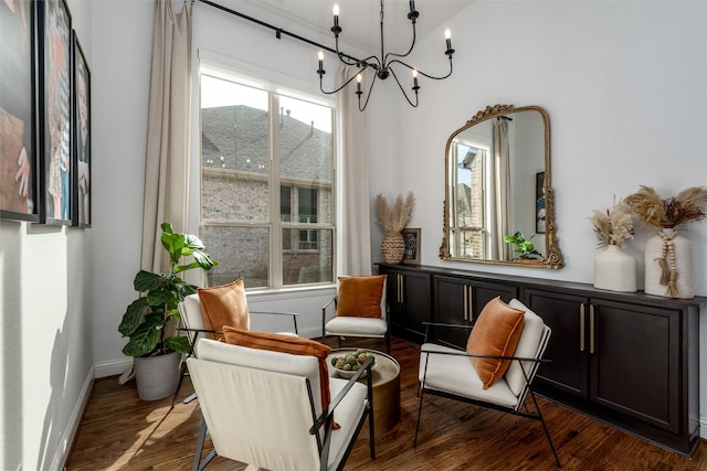 living area featuring a notable chandelier, baseboards, and wood finished floors