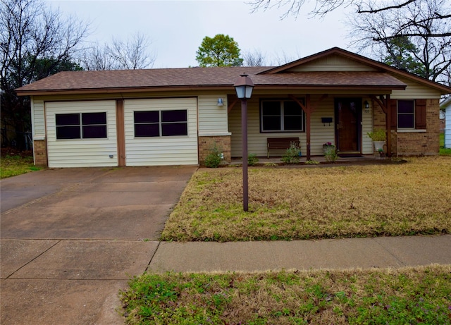 view of front facade with an attached garage, brick siding, a porch, and a front yard