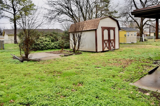 view of yard featuring a shed, an outdoor structure, and a fenced backyard