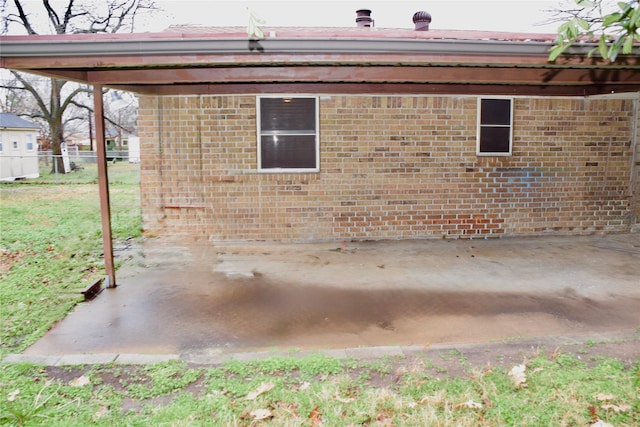 view of side of home with fence and brick siding