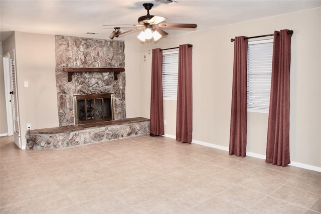 unfurnished living room featuring baseboards, a fireplace, visible vents, and a ceiling fan