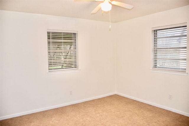 spare room with plenty of natural light, baseboards, and ceiling fan