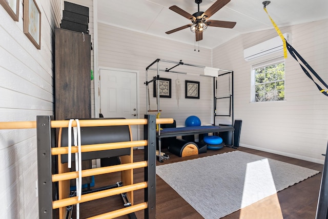 interior space with a ceiling fan, an AC wall unit, baseboards, and wood finished floors