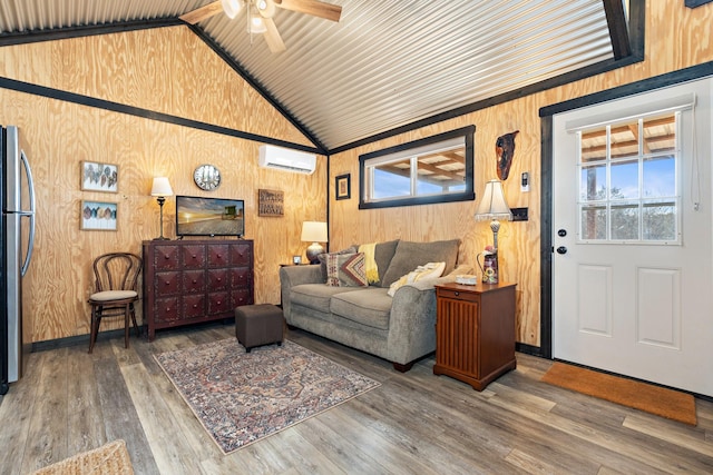 living room with ceiling fan, wooden walls, wood finished floors, high vaulted ceiling, and a wall mounted air conditioner