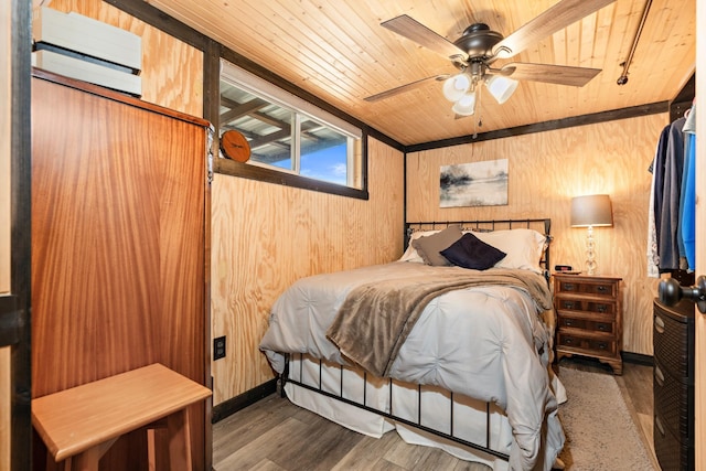 bedroom with wood walls, wood finished floors, wood ceiling, and a ceiling fan