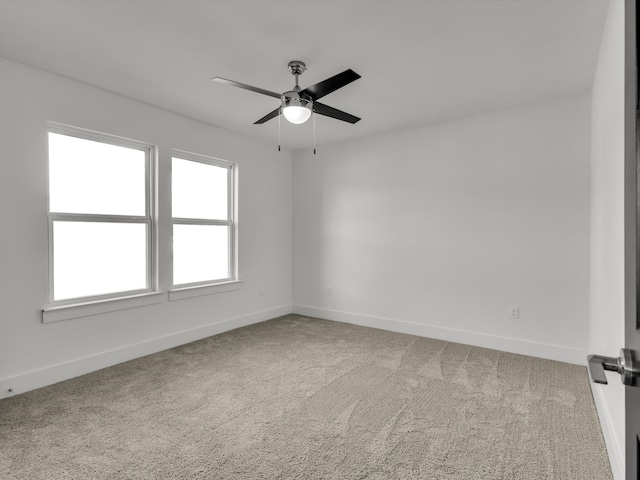 empty room with a ceiling fan, carpet flooring, and baseboards