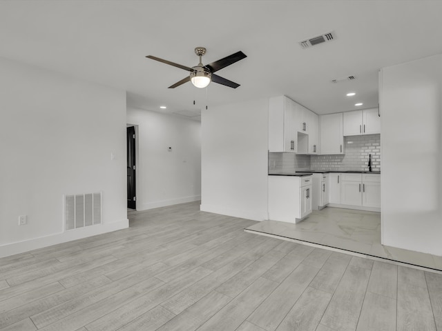 interior space featuring open floor plan, tasteful backsplash, a sink, and visible vents