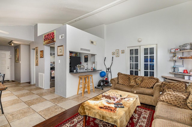 living room featuring high vaulted ceiling, french doors, and visible vents