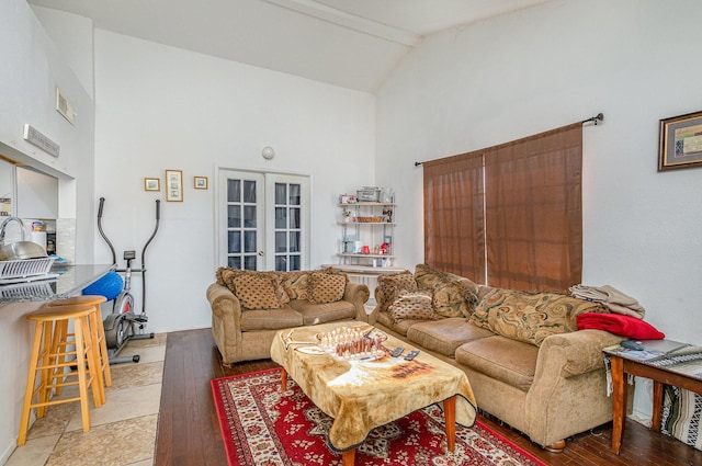 living room featuring visible vents, high vaulted ceiling, french doors, and light wood-style flooring