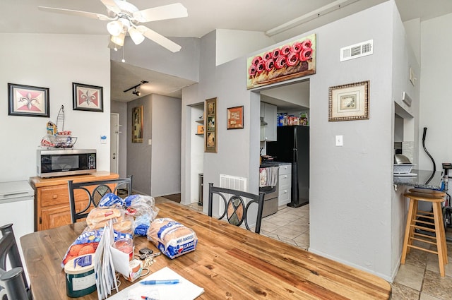 dining space featuring lofted ceiling, track lighting, visible vents, and a ceiling fan