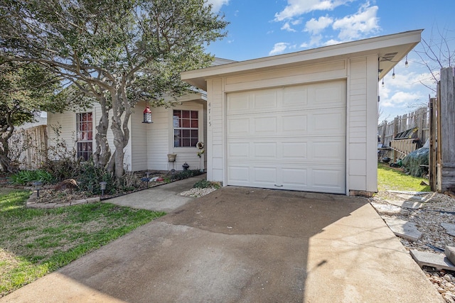 ranch-style house featuring a garage, fence, and concrete driveway