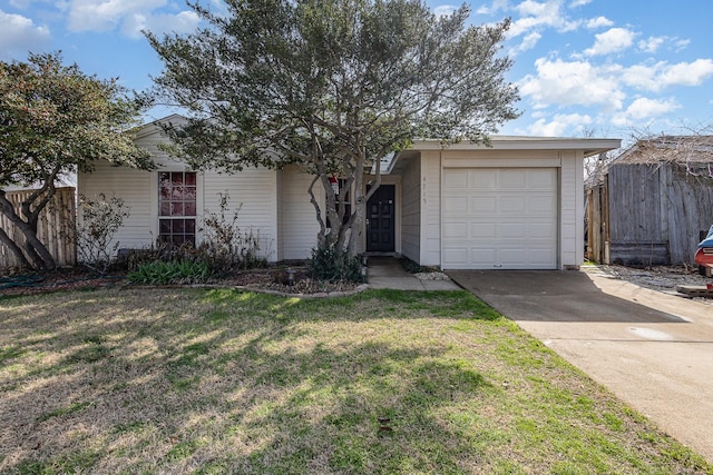 view of front of property featuring a garage, driveway, fence, and a front yard