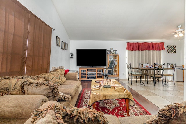 tiled living room with vaulted ceiling and ceiling fan