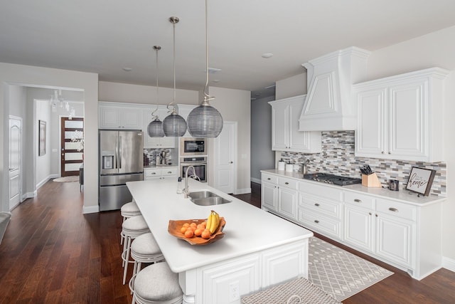 kitchen featuring a sink, stainless steel appliances, dark wood-style floors, and decorative backsplash