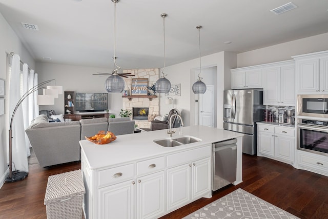 kitchen with a fireplace, visible vents, stainless steel appliances, and a sink