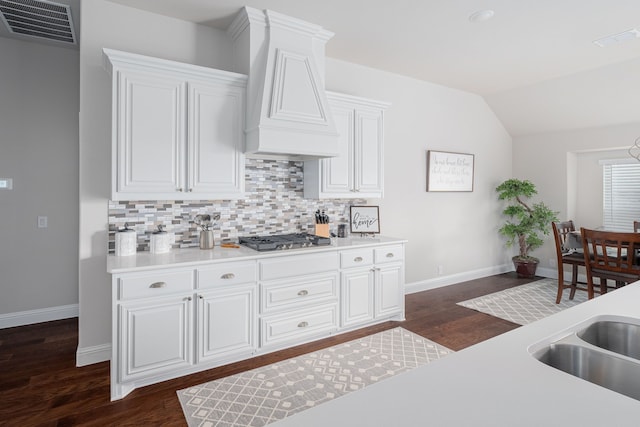 kitchen featuring visible vents, premium range hood, stainless steel gas cooktop, light countertops, and backsplash