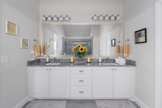 bathroom featuring a sink, baseboards, and double vanity