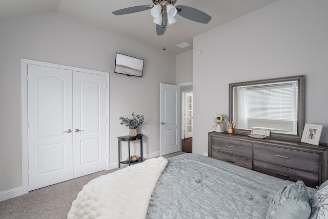 bedroom featuring a closet, baseboards, carpet, and lofted ceiling