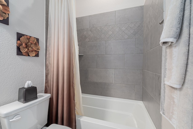 full bathroom featuring toilet, shower / bath combo, and a textured wall