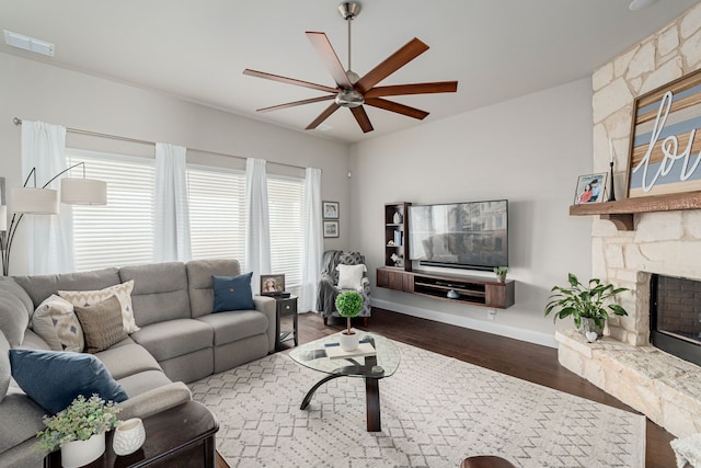 living area featuring visible vents, baseboards, ceiling fan, dark wood finished floors, and a fireplace