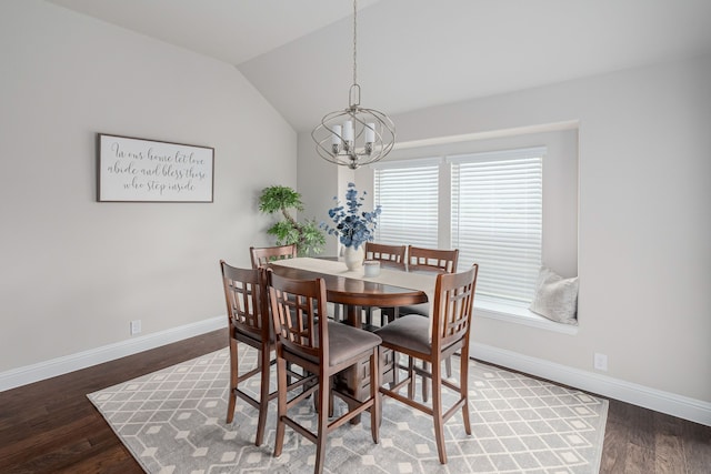dining room with a notable chandelier, wood finished floors, baseboards, and vaulted ceiling