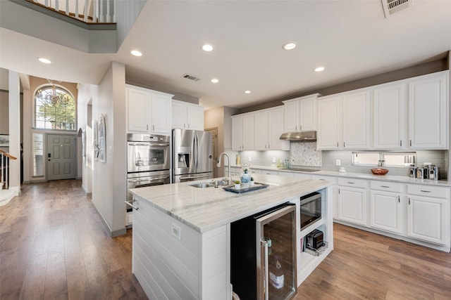 kitchen with stainless steel fridge, visible vents, wine cooler, built in microwave, and under cabinet range hood